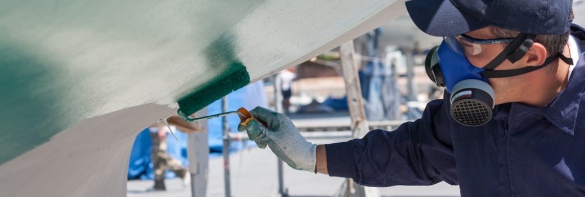 Man applying boat lacquer with a roller