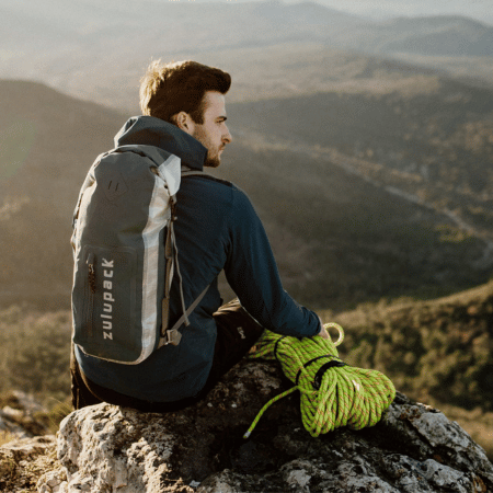 homme en montagne avec sac etanche