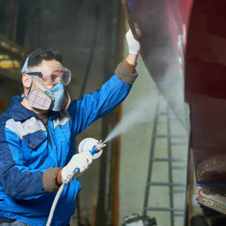 Homme qui applique un antifouling sur coque bateau