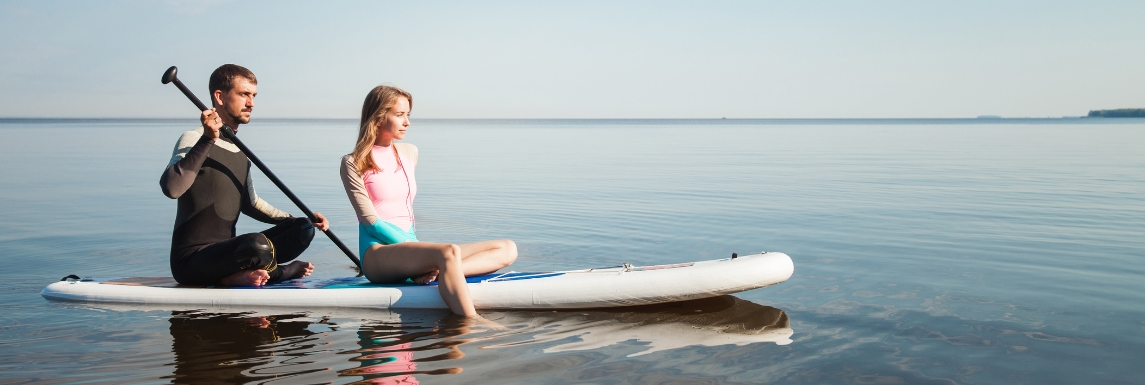 Homme et femme portant des vêtements anti UV sur un paddle